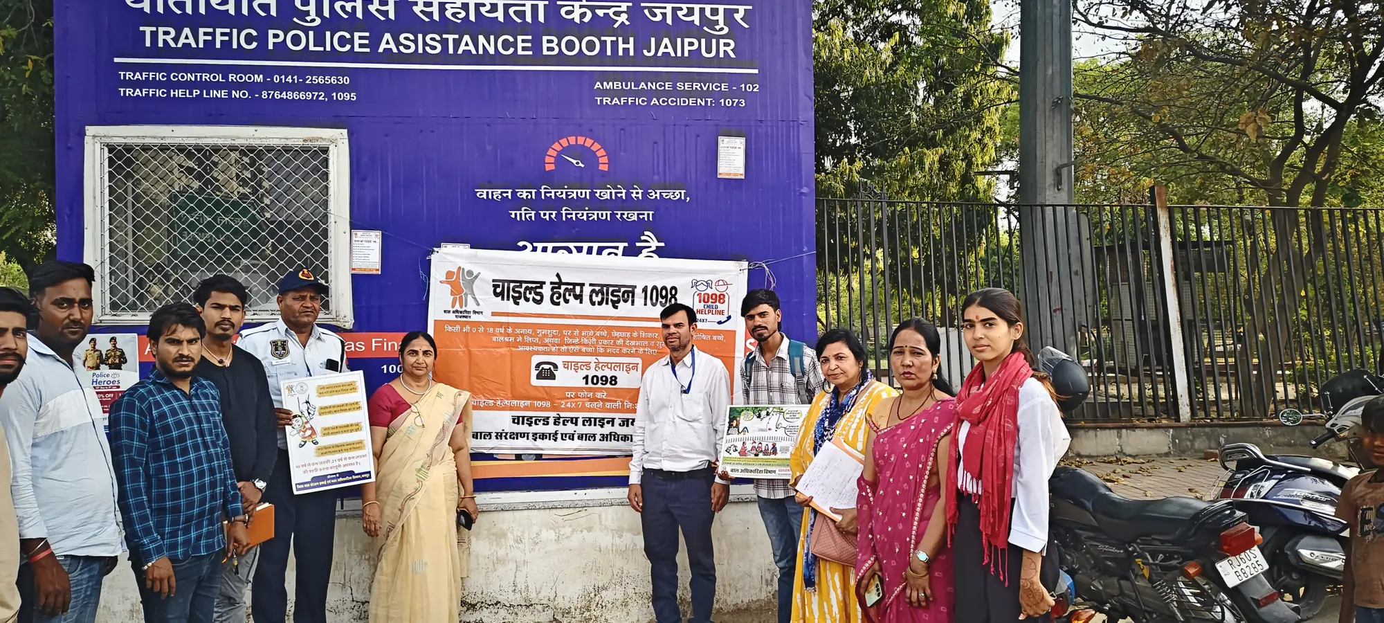 Foundation volunteers beside a Child Helpline 1098 banner at a Jaipur Traffic Police assistance booth.